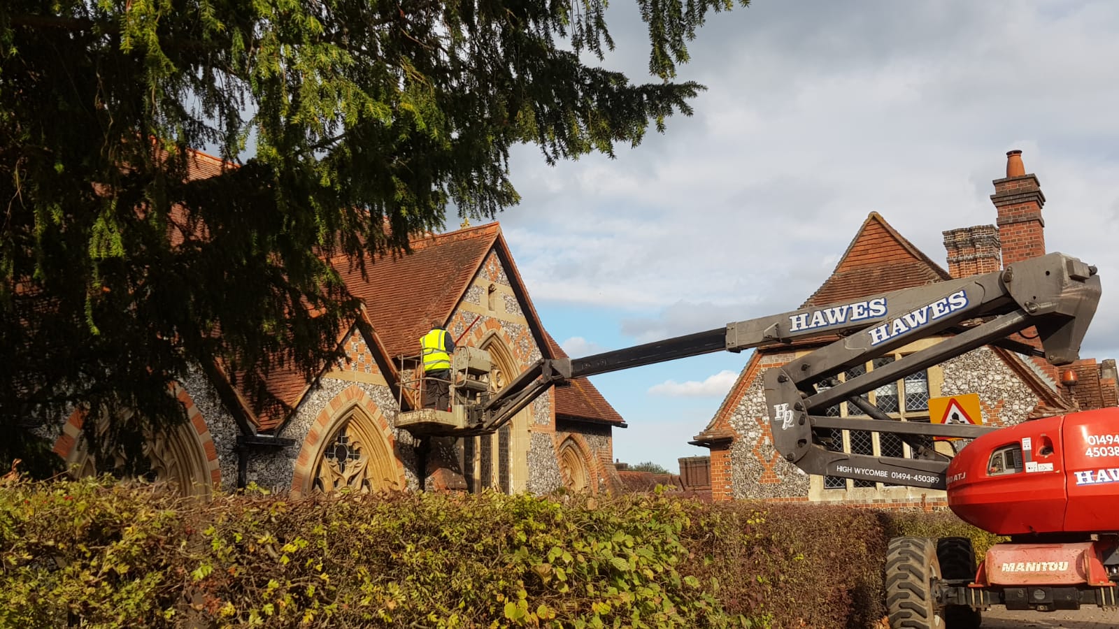 High-reach gutter clearance being carried out from a cherry picker